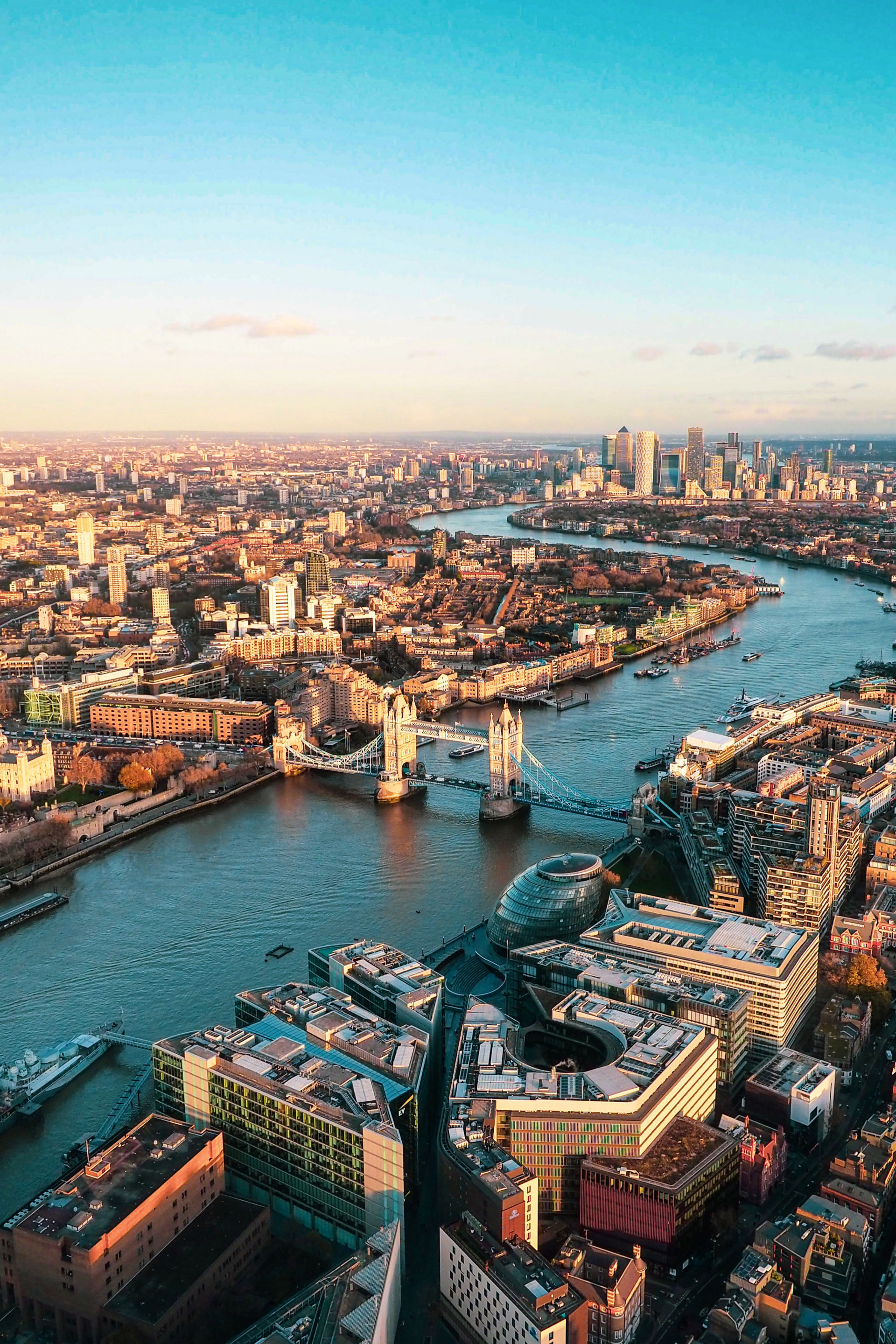 A view of London and the Thames River taken from above on a clear, sunny day