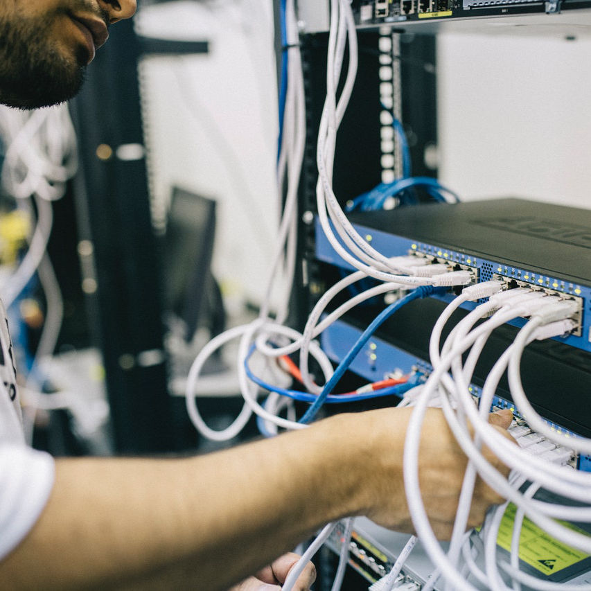 Engineer working on a server with wires and cables everywhere